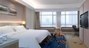 XinfengにあるVienna Hotel Xinfeng West High-Speed Railway Stationの大きなベッドとテレビがあるホテルの部屋