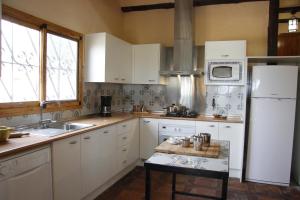 a kitchen with white cabinets and a white refrigerator at Casa Mola in Perelló