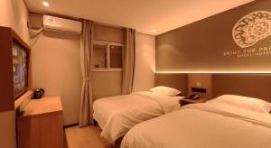 a hotel room with two beds and a television at Shell Hotel Beijing Shunyi District Shunyi Metro Station in Beijing +89 photos