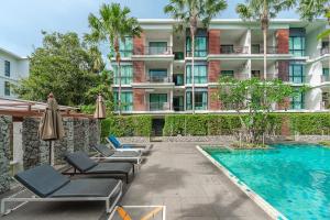 a hotel with lounge chairs and a swimming pool at C219 1BR Island Hideaway 500m to Rawai Beach in Rawai Beach