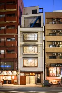 a tall white building next to two tall buildings at 廣島別邸 ダブルルーム Hiroshima Villa for 2ppl - Supported by COCOSTAY in Hiroshima