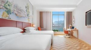 a hotel room with two beds and a desk and a window at Vienna Hotel Chongqing Wushan Municipal Government in Wushan