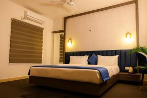 a bedroom with a large bed with a blue headboard at LAHR Hotels in Bangalore
