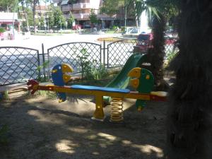 a playground in a park with a slide at Hotel Mimosa in Lignano Sabbiadoro