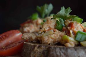 a sandwich with meat and vegetables and a tomato at Fiscardo Bay Hotel in Fiskardo