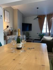 a bottle of champagne and two wine glasses on a table at L'écrin de Loire by Saumur Signature in Saumur