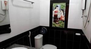 a bathroom with a toilet and a picture on the wall at Khamsaner Hotel in Vientiane
