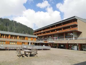 een groot gebouw met een bank ervoor bij Monolocale Alberti Rainalter in Madonna di Campiglio