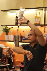 a man is holding up a drink in a glass at Rebel Rooster Hostel in Hanoi