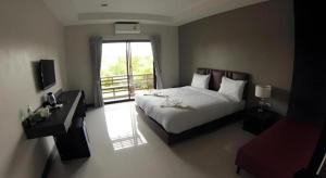 a hotel room with a bed and a balcony at Villa Thiwa Hotel in Ban Na Po Tai +44 photos