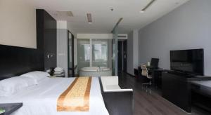 a bedroom with a large bed and a bathroom with a tub at Guangdong Nanmei Osotto Hotel in Guangzhou