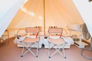 three chairs and a bed in a tent at Bangsaen Villa Hotel in Ban Laem Thaen