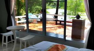 une chambre avec vue sur un patio avec une table et des chaises dans l'établissement Rommai Rimnaam Resort, à Ban Bang Rin (1)