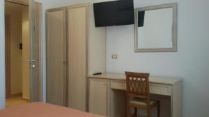 a room with a desk with a chair and a mirror at Hotel Corallo in Torre Santa Sabina