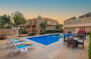 een zwembad in een hotel met stoelen en een tafel bij Zone Connect by The Park Jaisalmer in Jaisalmer