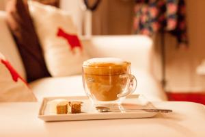 a cup of coffee and a piece of cake on a table at The Ibis Lounge in Nieu-Bethesda