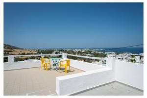 a table and chairs on a balcony with a view of the ocean at kosmas rooms in Skiros