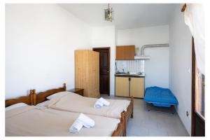 a room with two beds and a kitchen in it at kosmas rooms in Skiros