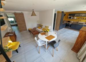 Una cocina y una sala de estar con mesa y sillas. en MAISON à la CAMPAGNE, en Hommes