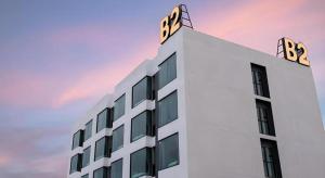 a white building with two signs on top of it at B2 Mukdahan Boutique and Budget Hotel in Mukdahan