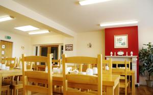 a dining room with wooden tables and chairs at Teach Greannai Accommodation Pod in Ross Port