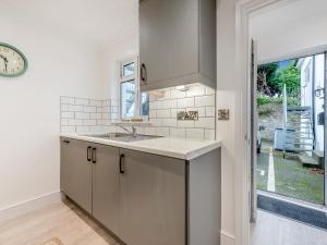 a kitchen with a sink and a clock on the wall at Long Ships - Uk48322 in Saundersfoot +16 photos