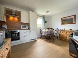 a kitchen and dining room with a table and chairs at The Old Surgery in Kinlochbervie