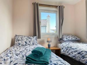 a bedroom with two beds and a window at The Old Surgery in Kinlochbervie