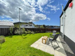 a patio with a chair and a table in a yard at The Old Surgery in Kinlochbervie