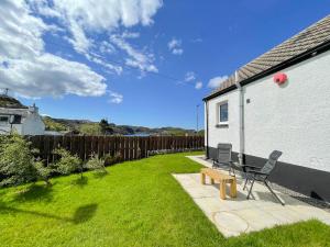 a yard with a bench and a house at The Old Surgery in Kinlochbervie