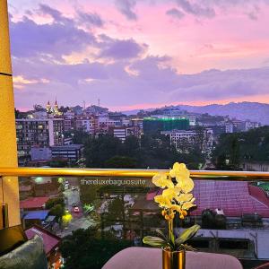 a vase with yellow flowers sitting on a table in a window at The ReLuxe Baguio Suite CityHub in Baguio +33 photos