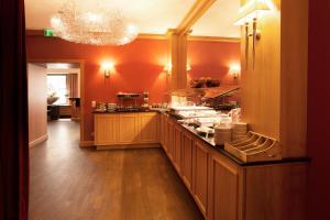 a kitchen with orange walls and a counter with dishes at TOWNHOUSE Hotel in Frankfurt +29 photos