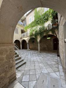 an archway in a building with a courtyard with stairs at Ameli Heritage rooms & apartments in Zadar