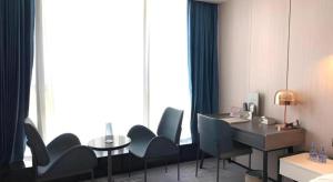 a room with chairs and a desk and a table at Golden Central Hotel Shenzhen in Shenzhen