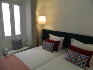 a bedroom with a bed with pillows on it at Enjoy Casa do Forte Apartment in Lisbon