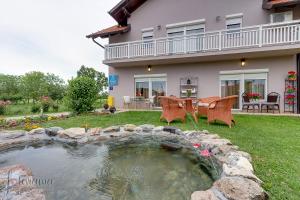 ein Haus mit einem Teich im Hof in der Unterkunft Rooms Stanic in Velika Gorica