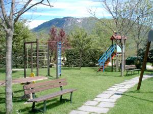 a park with benches and a playground with a slide at Agriturismo La Bordiga in Paesana