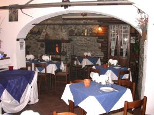 a restaurant with blue tables and chairs and a stone wall at Agriturismo La Bordiga in Paesana