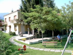 a person sitting on a park bench under a tree at Agriturismo La Bordiga in Paesana