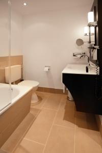 
a bathroom with a sink, toilet and bathtub at Hotel Villa Florentina in Frankfurt/Main
