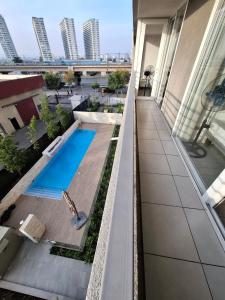 a balcony with a swimming pool on a building at Loica Host - Departamentos amoblados a pasos del metro in Santiago
