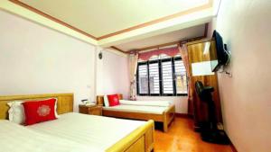 ein Schlafzimmer mit zwei Betten und einem Fenster in der Unterkunft Kiên Cường Hostel in Sa Pa