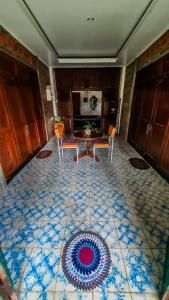 a room with a table and chairs on a tiled floor at Rumah Gaharu - Kulon 