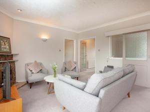 a living room with two couches and a fireplace at Leighwood Cottage in Paignton