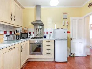 a kitchen with a refrigerator and a stove at River Cottage in Two Dales