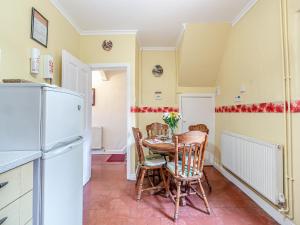 a kitchen with a table and chairs and a refrigerator at River Cottage in Two Dales +14 photos
