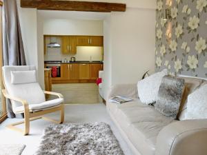 a living room with a white couch and a chair at Black Thorn Cottage in Falmouth