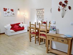 a living room with a table and a white couch at Black Thorn Cottage in Falmouth