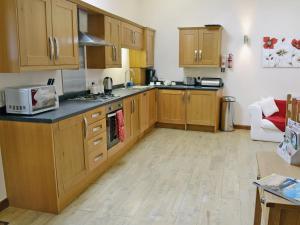 a kitchen with wooden cabinets and a counter top at Black Thorn Cottage in Falmouth