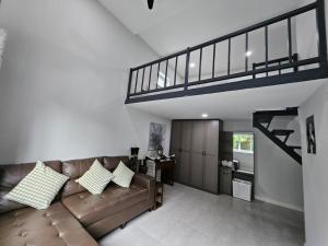 a living room with a couch and a staircase at Unique House with Golf Net, Pool Table & Swimming in Ban Thung Satong